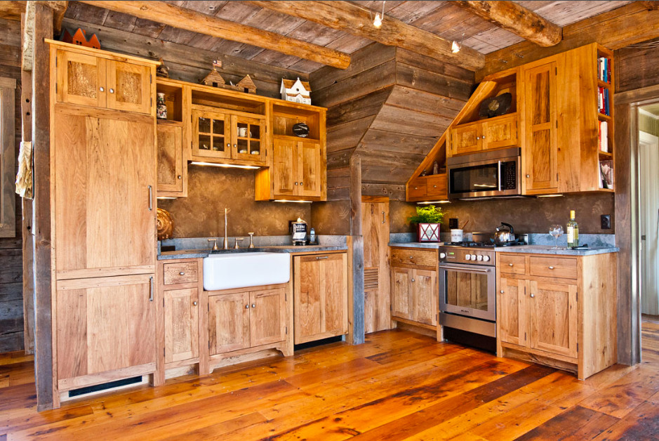 Example of a mid-sized mountain style l-shaped medium tone wood floor open concept kitchen design in Boston with a farmhouse sink, shaker cabinets, light wood cabinets, concrete countertops, paneled appliances and no island