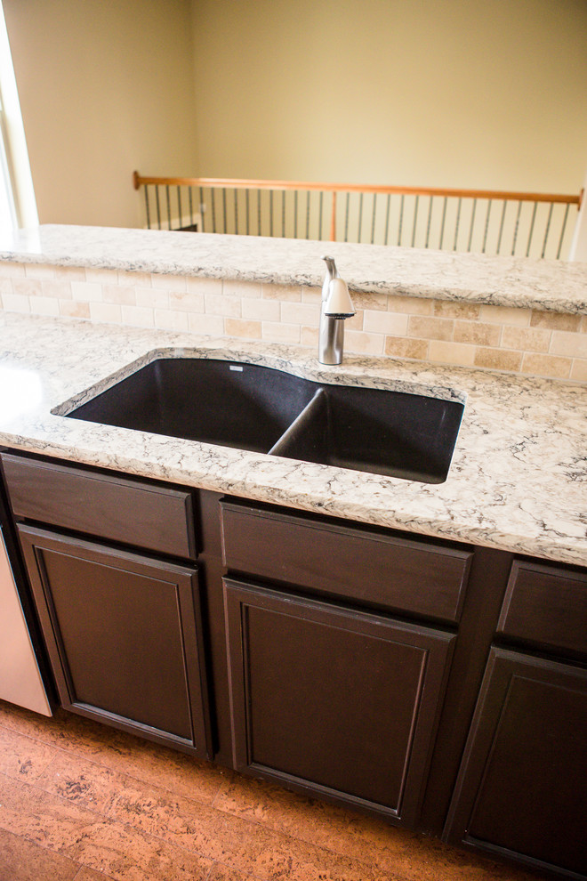 Eat-in kitchen - mid-sized transitional l-shaped medium tone wood floor eat-in kitchen idea in Austin with an undermount sink, recessed-panel cabinets, white cabinets, granite countertops, beige backsplash, stone tile backsplash, stainless steel appliances and an island