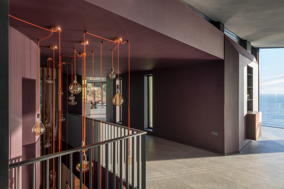 На фото: большой коридор в современном стиле с фиолетовыми стенами и серым полом с