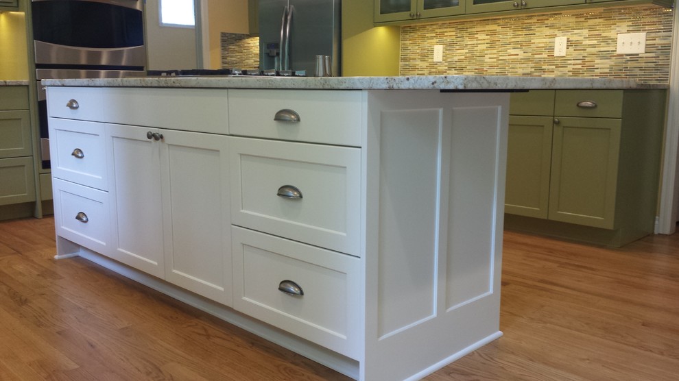 Kitchen - large transitional u-shaped medium tone wood floor kitchen idea in Seattle with a double-bowl sink, recessed-panel cabinets, white cabinets, granite countertops, multicolored backsplash, mosaic tile backsplash, stainless steel appliances and an island