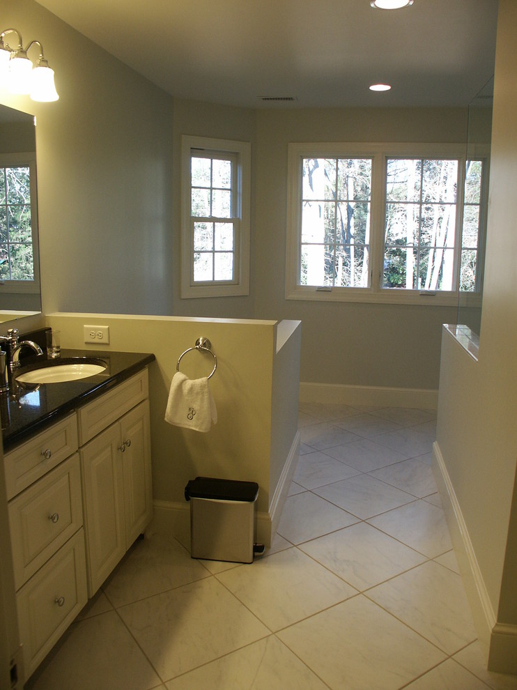 Inspiration for a large transitional master bathroom in Charlotte with raised-panel cabinets, white cabinets, a corner shower, a two-piece toilet, white tile, ceramic tile, white walls, ceramic floors, an undermount sink and engineered quartz benchtops.