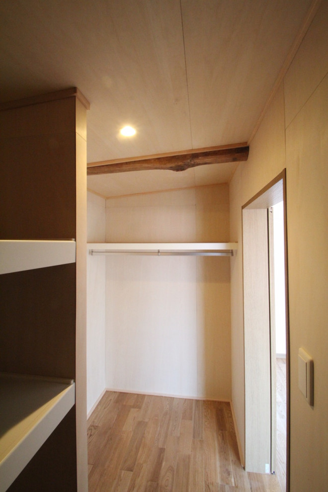 Idee per una piccola cabina armadio per uomo scandinava con pavimento in legno massello medio, pavimento marrone e travi a vista