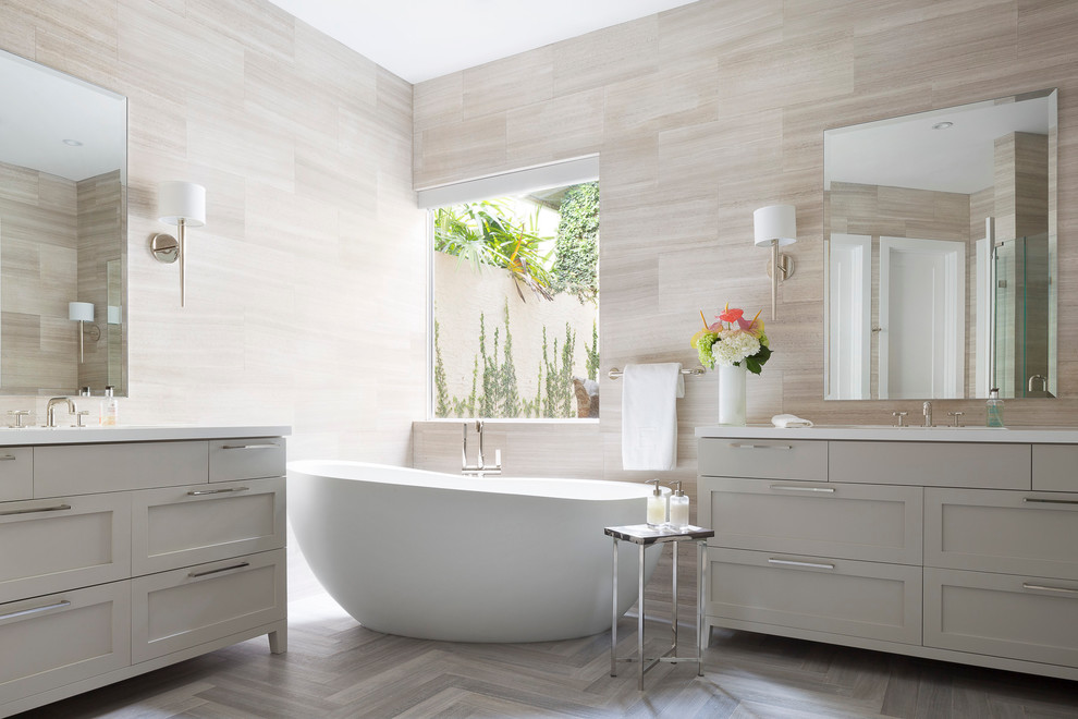 Inspiration for a large transitional master bathroom in Miami with an integrated sink, shaker cabinets, grey cabinets, quartzite benchtops, a freestanding tub, beige tile, limestone floors, limestone and grey floor.