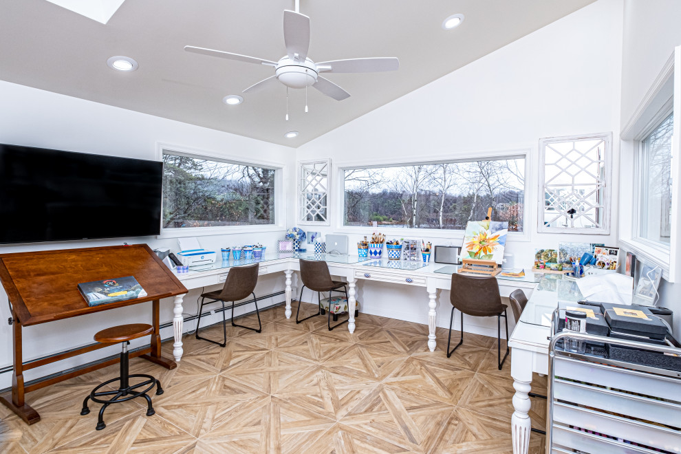 Inspiration for a mid-sized eclectic freestanding desk porcelain tile, brown floor and vaulted ceiling craft room remodel in New York with white walls