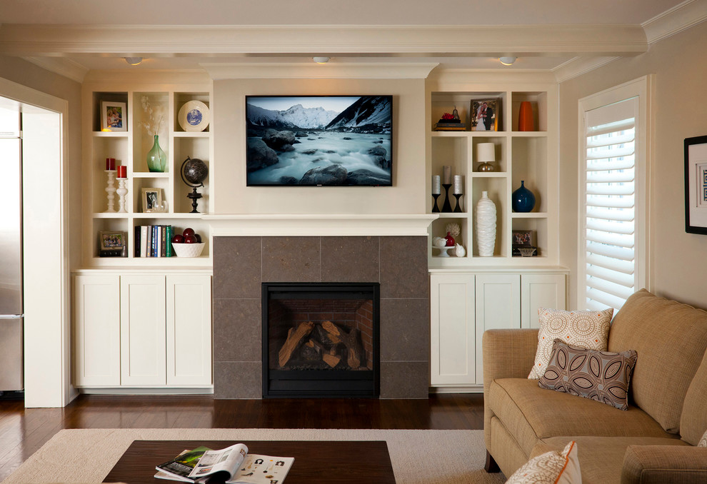 This is an example of a small traditional living room in Cincinnati with grey walls, dark hardwood floors, a standard fireplace, a tile fireplace surround and a wall-mounted tv.