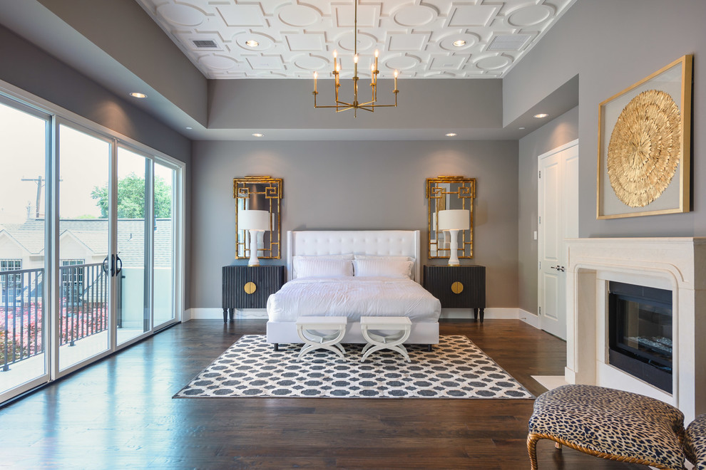 This is an example of a transitional master bedroom in Dallas with grey walls, dark hardwood floors and a standard fireplace.