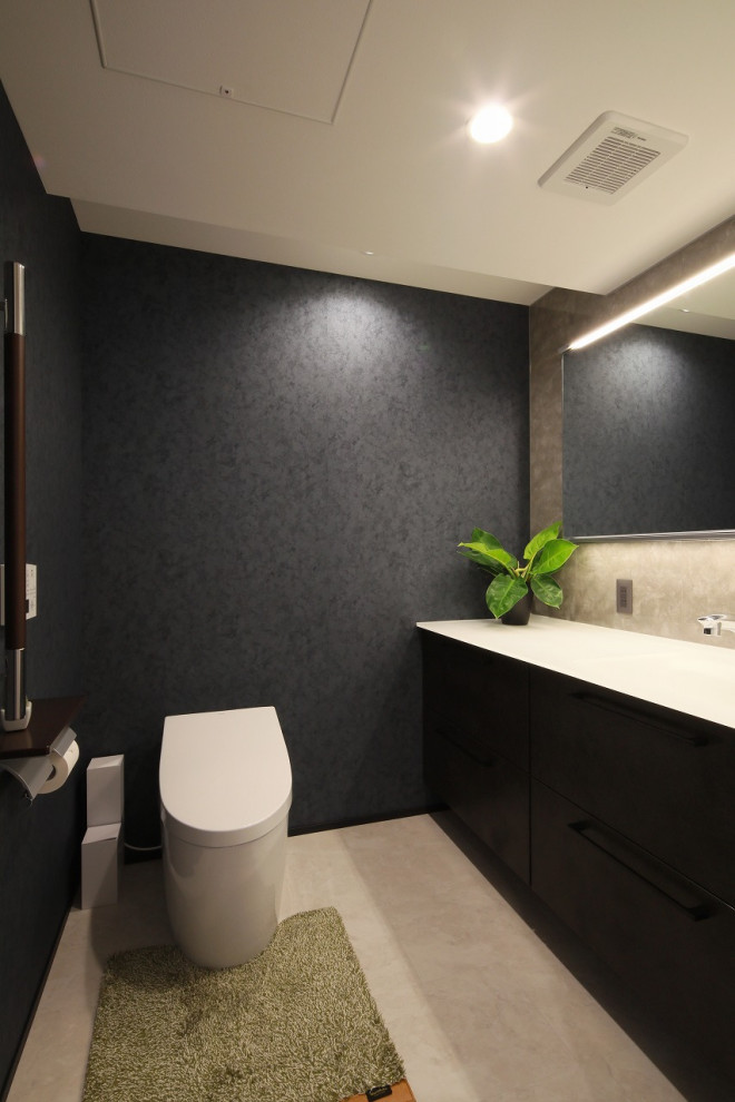 Minimalist gray tile vinyl floor, beige floor, wallpaper ceiling and wallpaper powder room photo in Other with a one-piece toilet, blue walls, an undermount sink, white countertops and a built-in vanity