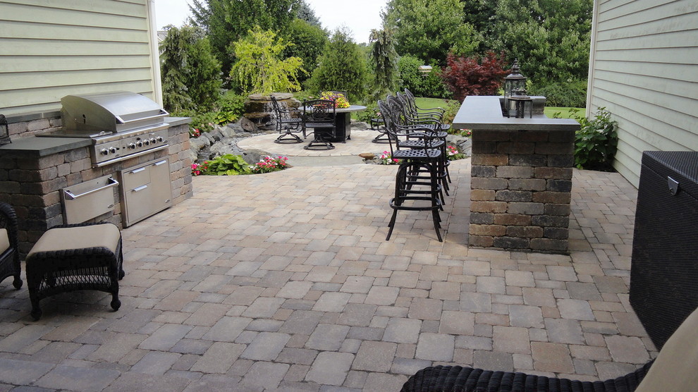 Photo of a contemporary backyard patio in Chicago with an outdoor kitchen, brick pavers and no cover.