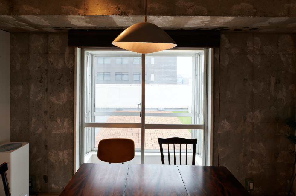 Foto di una sala da pranzo aperta verso il soggiorno industriale di medie dimensioni con pareti grigie, pavimento in cemento, pavimento grigio e travi a vista