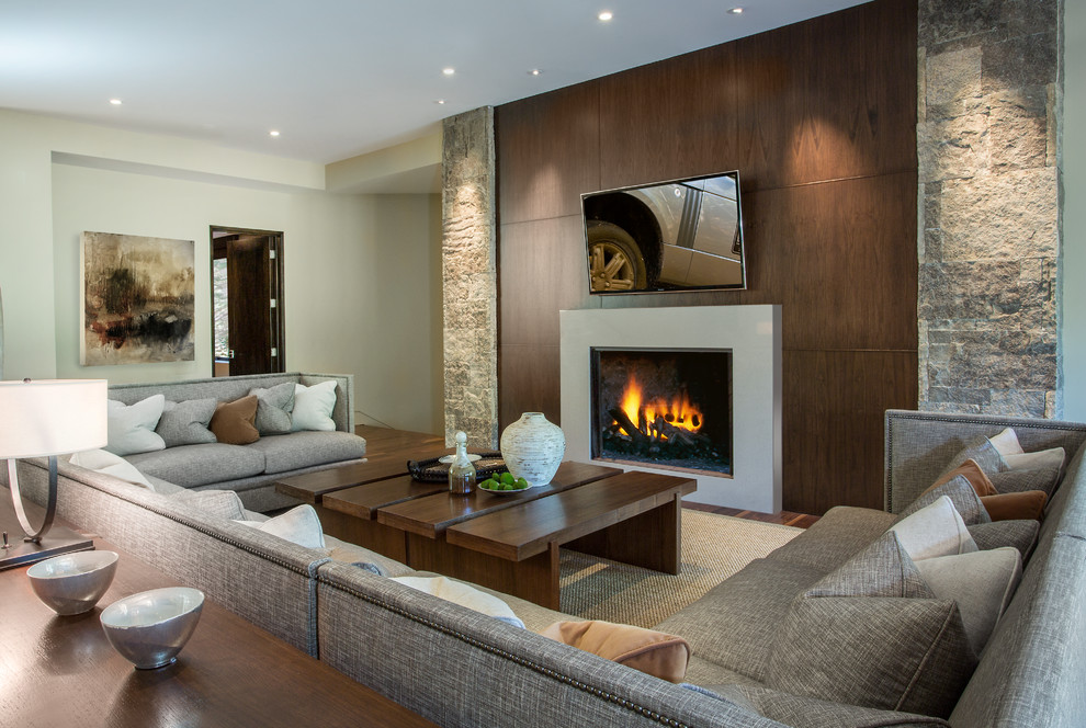 Design ideas for a large contemporary formal enclosed living room in Salt Lake City with beige walls, dark hardwood floors, a standard fireplace, a stone fireplace surround, no tv and brown floor.