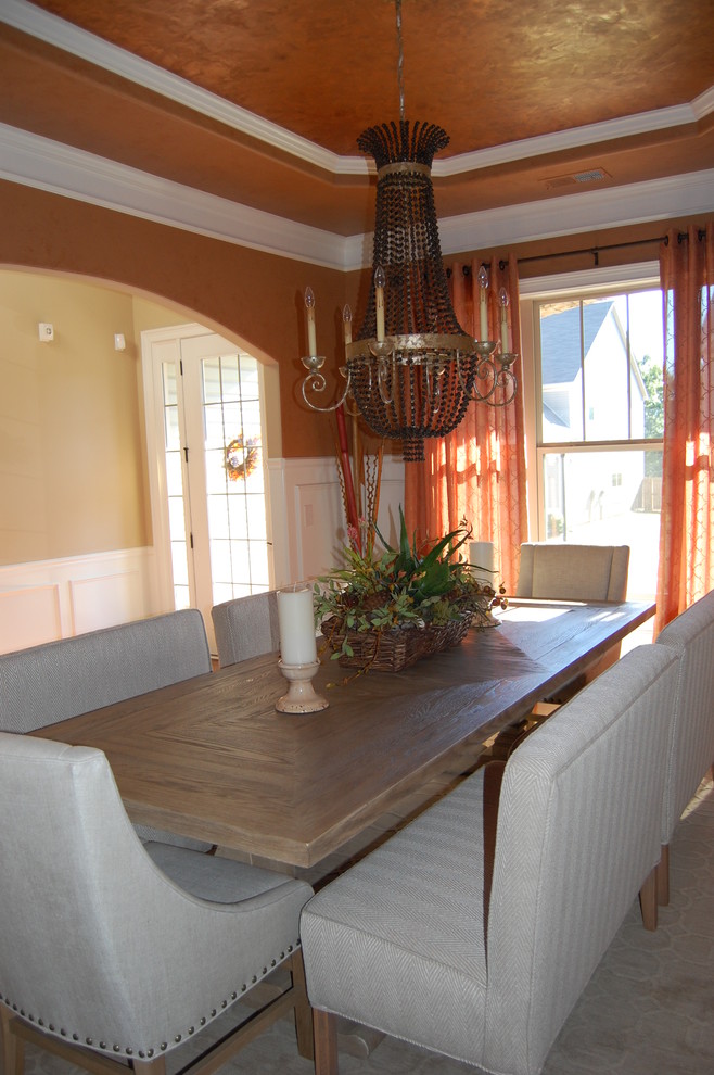 Photo of a mid-sized eclectic separate dining room in Other with orange walls, carpet, no fireplace and beige floor.