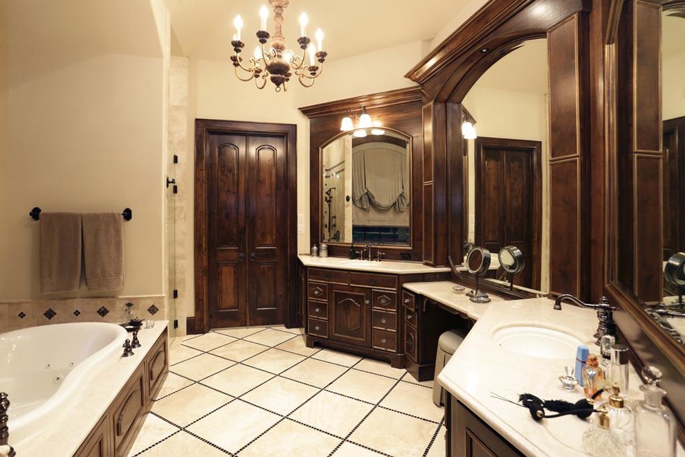 This is an example of a large traditional master bathroom in Houston with furniture-like cabinets, dark wood cabinets, an alcove tub, beige tile, ceramic tile, beige walls, ceramic floors, an undermount sink and solid surface benchtops.