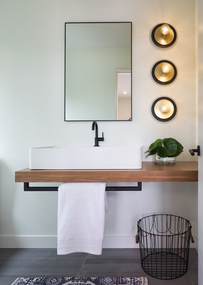 Small trendy porcelain tile and gray floor bathroom photo in Minneapolis with white walls, a vessel sink and wood countertops