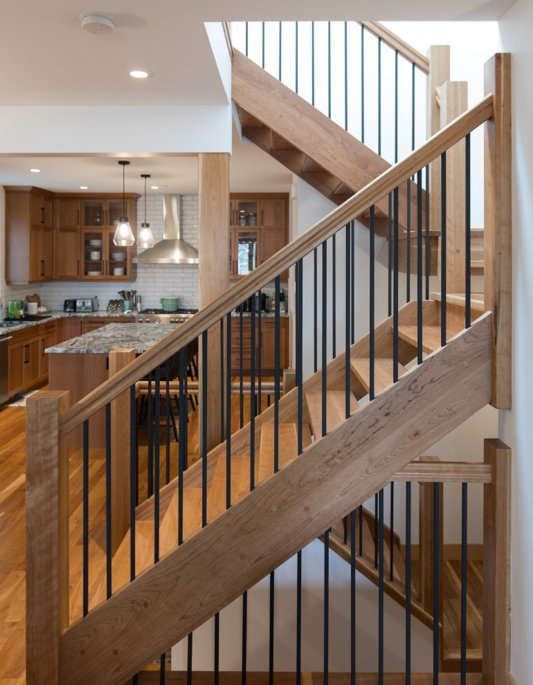 Inspiration for a country wood u-shaped staircase in Calgary with open risers and mixed railing.