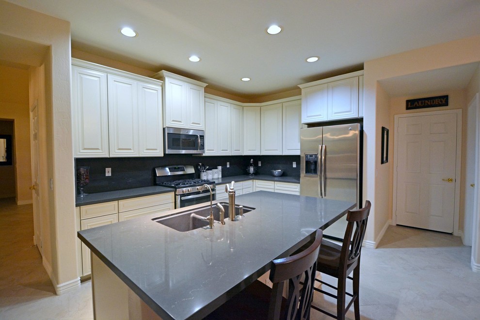 Example of a mid-sized transitional l-shaped marble floor open concept kitchen design in Phoenix with shaker cabinets, white cabinets, gray backsplash, an island, a double-bowl sink, quartz countertops, stone slab backsplash and stainless steel appliances