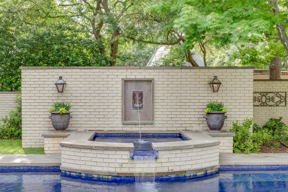 Traditional courtyard custom-shaped pool in Dallas with a water feature.