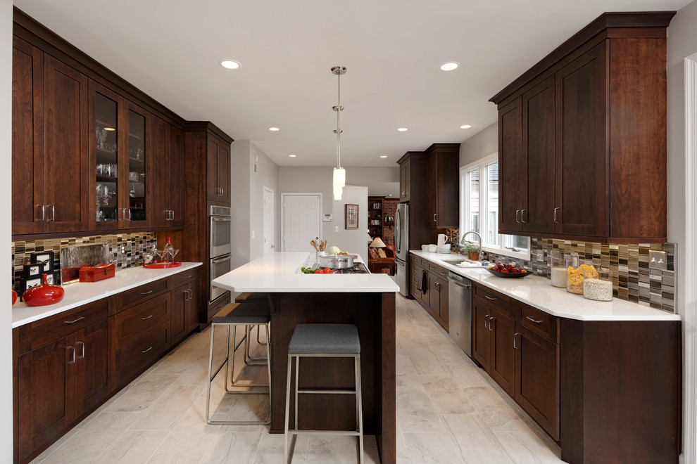 Example of a mid-sized transitional l-shaped ceramic tile enclosed kitchen design in Baltimore with a single-bowl sink, flat-panel cabinets, dark wood cabinets, quartz countertops, metallic backsplash, mosaic tile backsplash, stainless steel appliances and an island