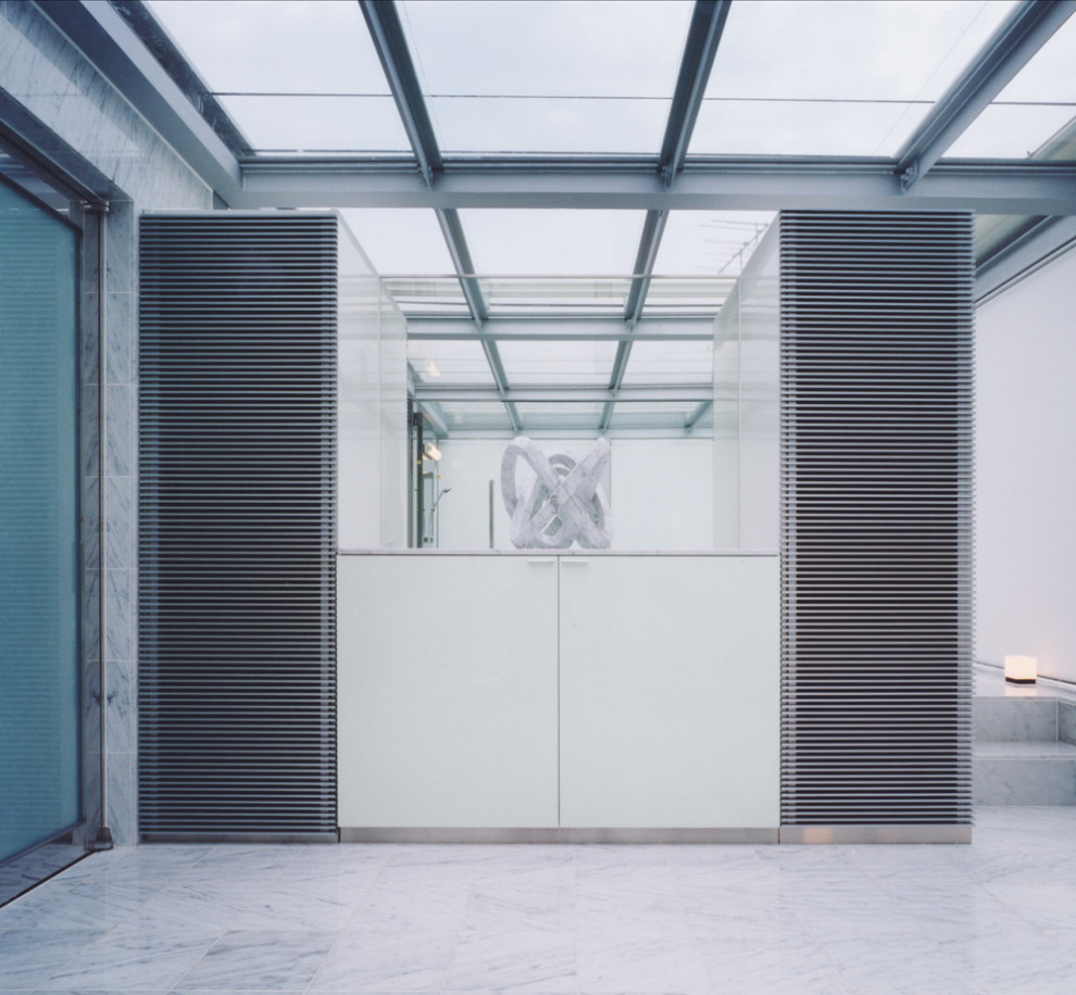 Bild på ett mellanstort funkis vit vitt en-suite badrum, med släta luckor, vita skåp, en jacuzzi, marmorgolv, marmorbänkskiva och vitt golv