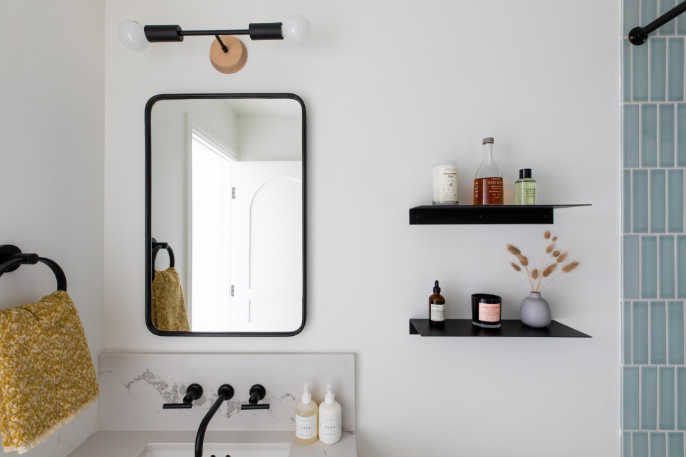 This is an example of a small scandinavian bathroom in San Francisco with flat-panel cabinets, light wood cabinets, an alcove tub, an alcove shower, blue tile, ceramic tile, white walls, ceramic floors, an undermount sink, engineered quartz benchtops, black floor, white benchtops, a niche, a single vanity and a floating vanity.