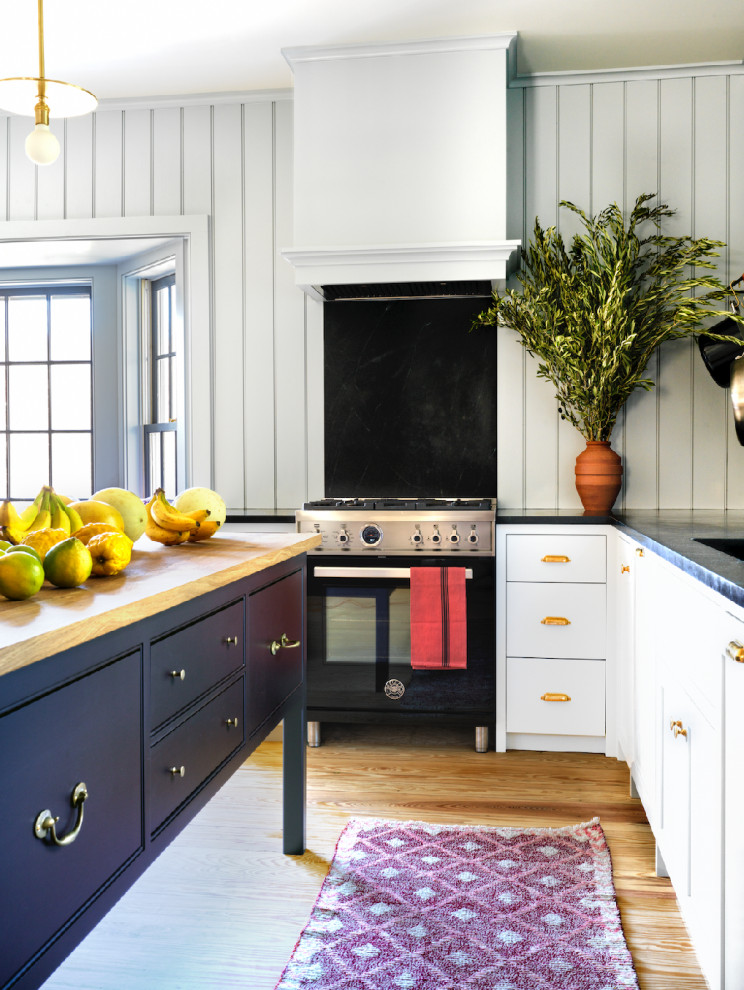 Immagine di una cucina abitabile minimalista con elettrodomestici neri, parquet chiaro e pavimento marrone