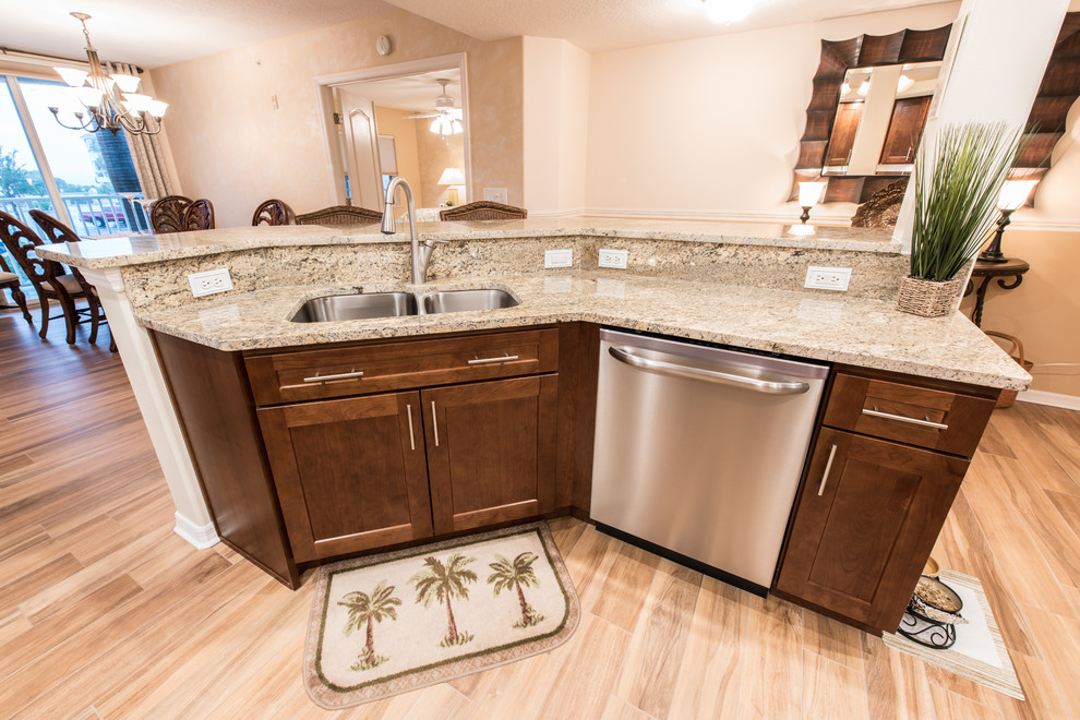 Eat-in kitchen - mid-sized transitional u-shaped porcelain tile eat-in kitchen idea with an undermount sink, shaker cabinets, dark wood cabinets, granite countertops, beige backsplash, stone tile backsplash, stainless steel appliances and an island