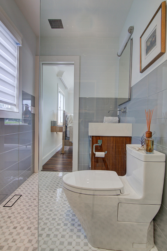 Photo of a small modern master bathroom in Other with flat-panel cabinets, brown cabinets, a curbless shower, a one-piece toilet, gray tile, glass tile, grey walls, marble floors, an undermount sink, quartzite benchtops, multi-coloured floor, an open shower, white benchtops, a niche, a single vanity and a freestanding vanity.