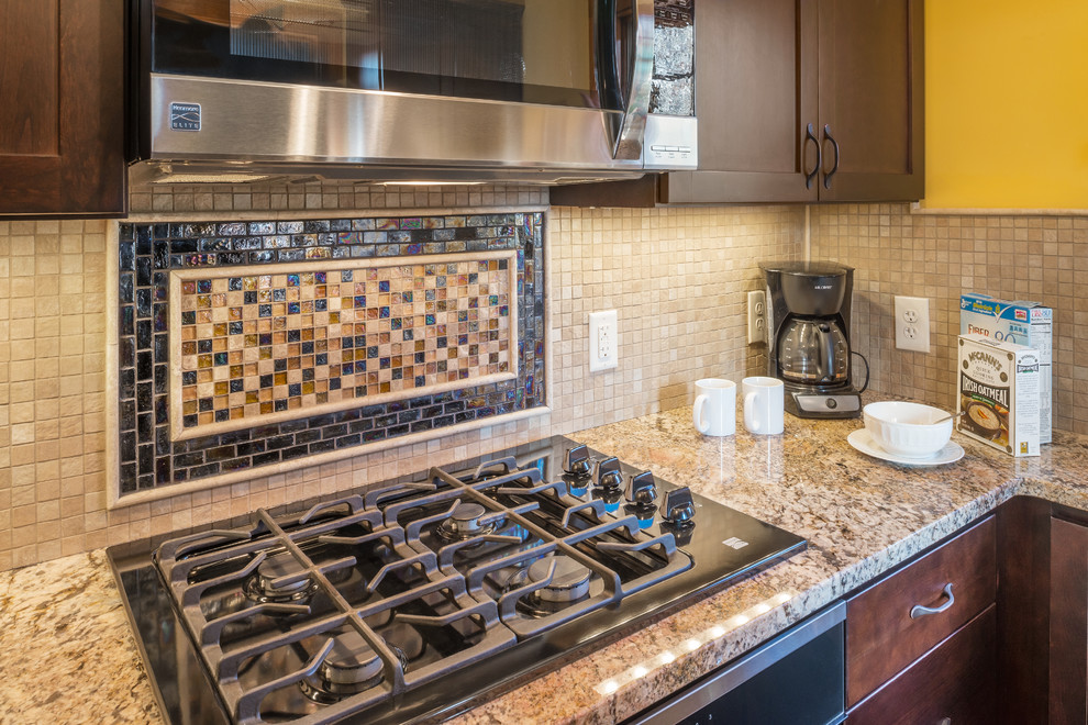 Eat-in kitchen - small rustic u-shaped eat-in kitchen idea in Providence with shaker cabinets, dark wood cabinets, granite countertops, beige backsplash, glass tile backsplash and stainless steel appliances