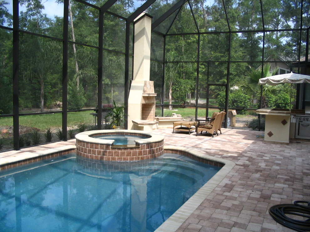 This is an example of a mid-sized traditional backyard rectangular lap pool in Jacksonville with a hot tub and brick pavers.
