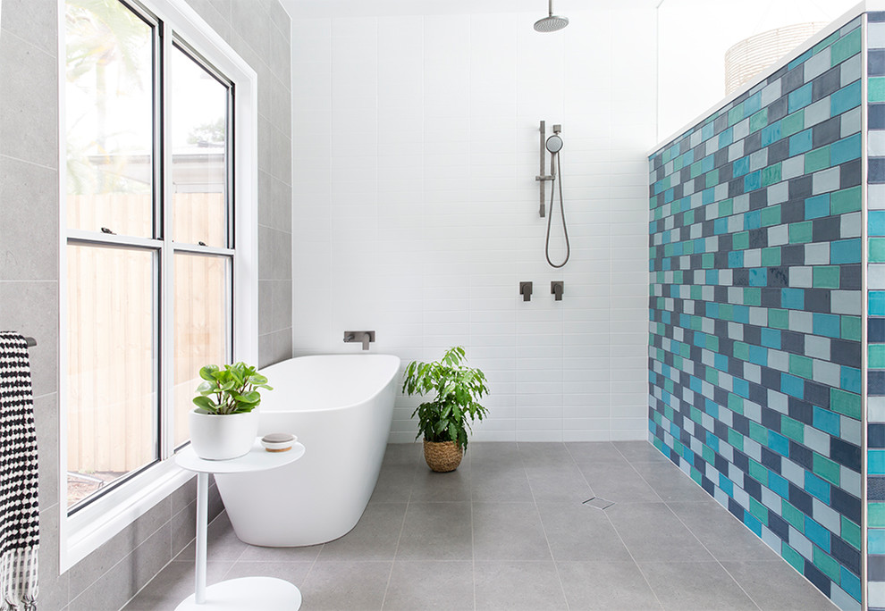 Beach style bathroom in Brisbane with a freestanding tub, blue tile, grey floor and an open shower.