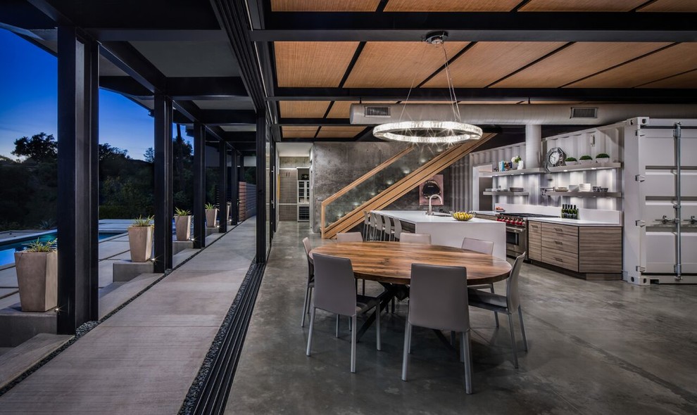 Industrial open plan dining in Santa Barbara with grey walls, concrete floors and grey floor.