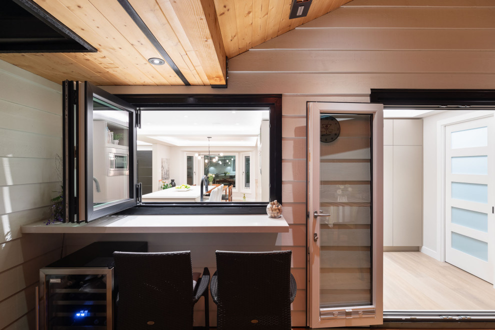 Medium sized traditional back ground level wood railing terrace in Vancouver with a fire feature and a roof extension.