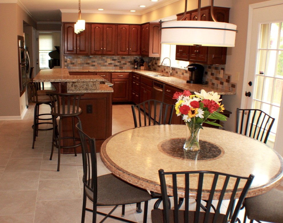 Mid-sized transitional l-shaped porcelain tile and gray floor eat-in kitchen photo in Cincinnati with an undermount sink, raised-panel cabinets, medium tone wood cabinets, granite countertops, multicolored backsplash, ceramic backsplash, stainless steel appliances and an island