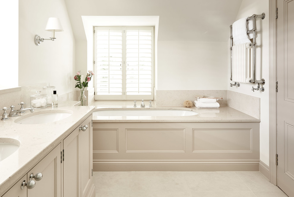 Design ideas for a traditional master bathroom in Wiltshire with recessed-panel cabinets, beige cabinets, an undermount tub, white walls, an undermount sink, beige floor and beige benchtops.