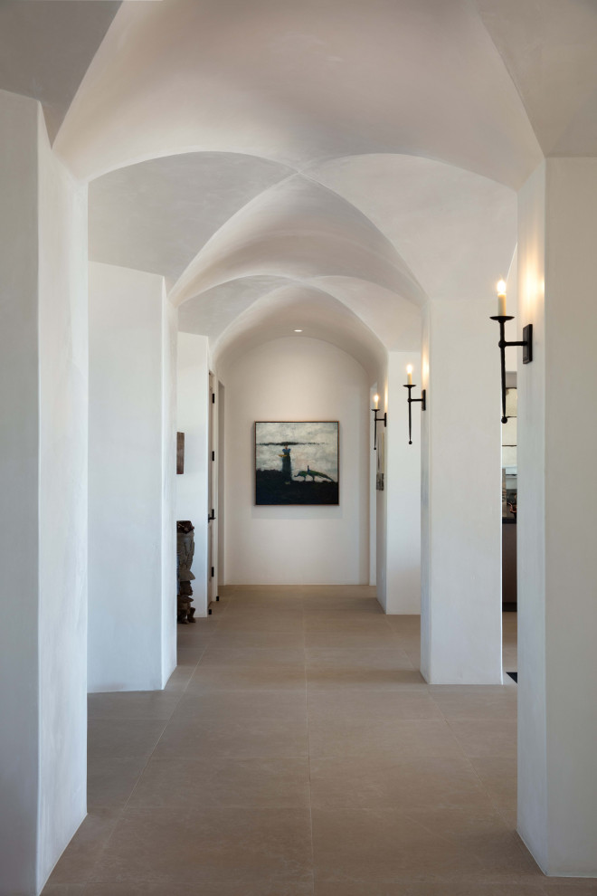 Exemple d'un couloir méditerranéen avec un mur blanc et un sol marron.