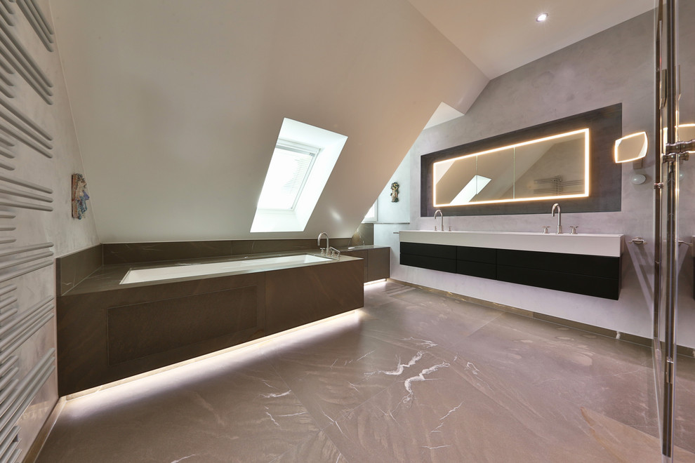 Badezimmer mit Whirlpool, Duschnische, Wandtoilette, grauen Fliesen, Marmorfliesen, grauer Wandfarbe, Marmorboden, Einbauwaschbecken, Mineralwerkstoff-Waschtisch, grauem Boden, Falttür-Duschabtrennung und weißer Waschtischplatte in Munich
