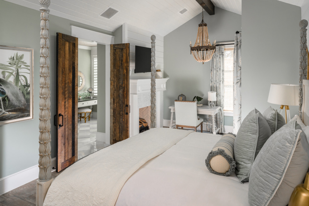Inspiration for a large traditional master bedroom in Houston with blue walls, medium hardwood floors, a standard fireplace, a wood fireplace surround, brown floor, timber and planked wall panelling.