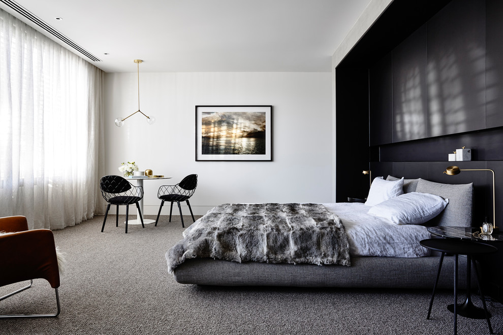 This is an example of a contemporary master bedroom in Melbourne with white walls and carpet.
