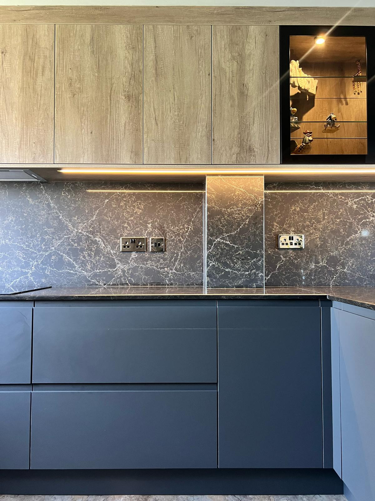 Eat-in kitchen - mid-sized contemporary u-shaped vinyl floor and brown floor eat-in kitchen idea in Other with a drop-in sink, flat-panel cabinets, dark wood cabinets, quartzite countertops, brown bac