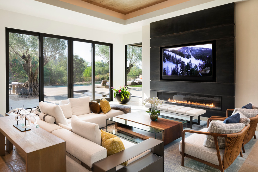 Large contemporary open concept family room in Sacramento with white walls, limestone floors, a standard fireplace, a metal fireplace surround, a built-in media wall and multi-coloured floor.