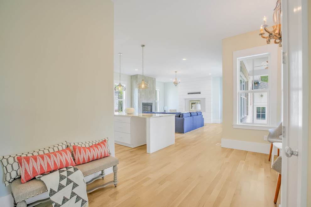 Hallway - mid-sized transitional single-wall light wood floor hallway idea with flat-panel cabinets, white cabinets, stainless steel appliances, an island and beige walls