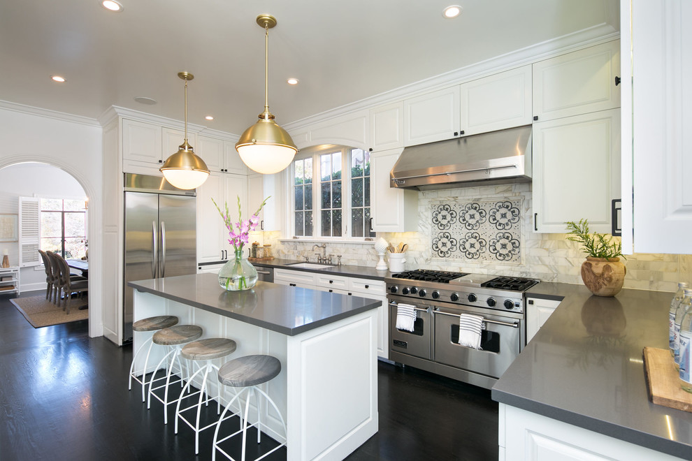 This is an example of a mid-sized traditional u-shaped separate kitchen in San Francisco with a single-bowl sink, raised-panel cabinets, white cabinets, quartzite benchtops, white splashback, marble splashback, stainless steel appliances, dark hardwood floors, with island, black floor and grey benchtop.