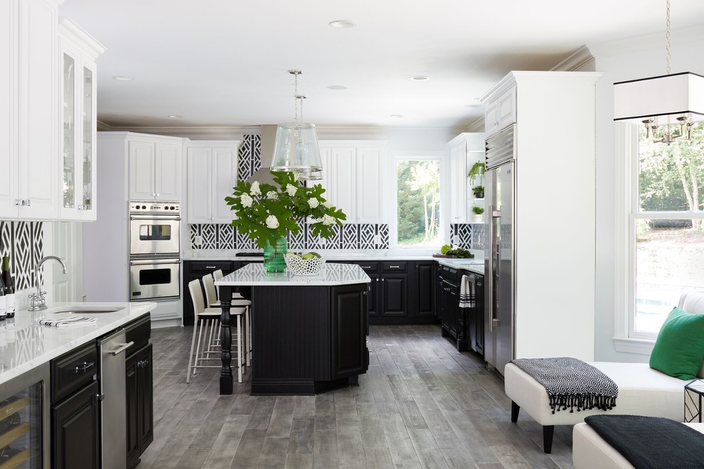 Transitional l-shaped medium tone wood floor and gray floor eat-in kitchen photo in DC Metro with an undermount sink, raised-panel cabinets, black cabinets, multicolored backsplash, stainless steel appliances, an island and white countertops