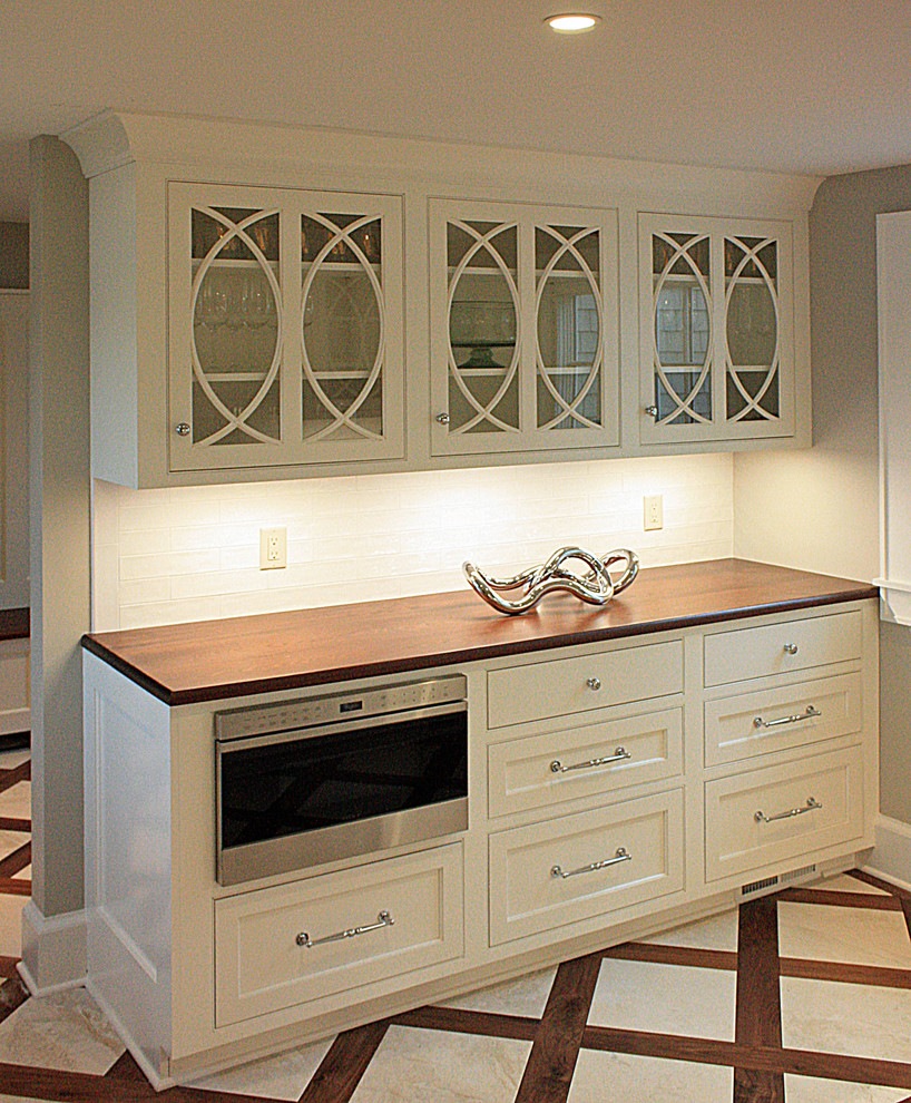 This is an example of a large traditional galley kitchen pantry in New York with beaded inset cabinets, white cabinets, granite benchtops, white splashback, ceramic splashback and with island.
