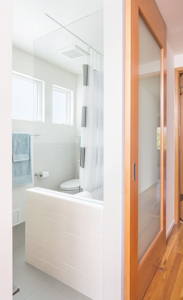 Mid-sized midcentury master bathroom in Seattle with flat-panel cabinets, light wood cabinets, an open shower, white tile, subway tile, white walls, porcelain floors, an integrated sink and engineered quartz benchtops.