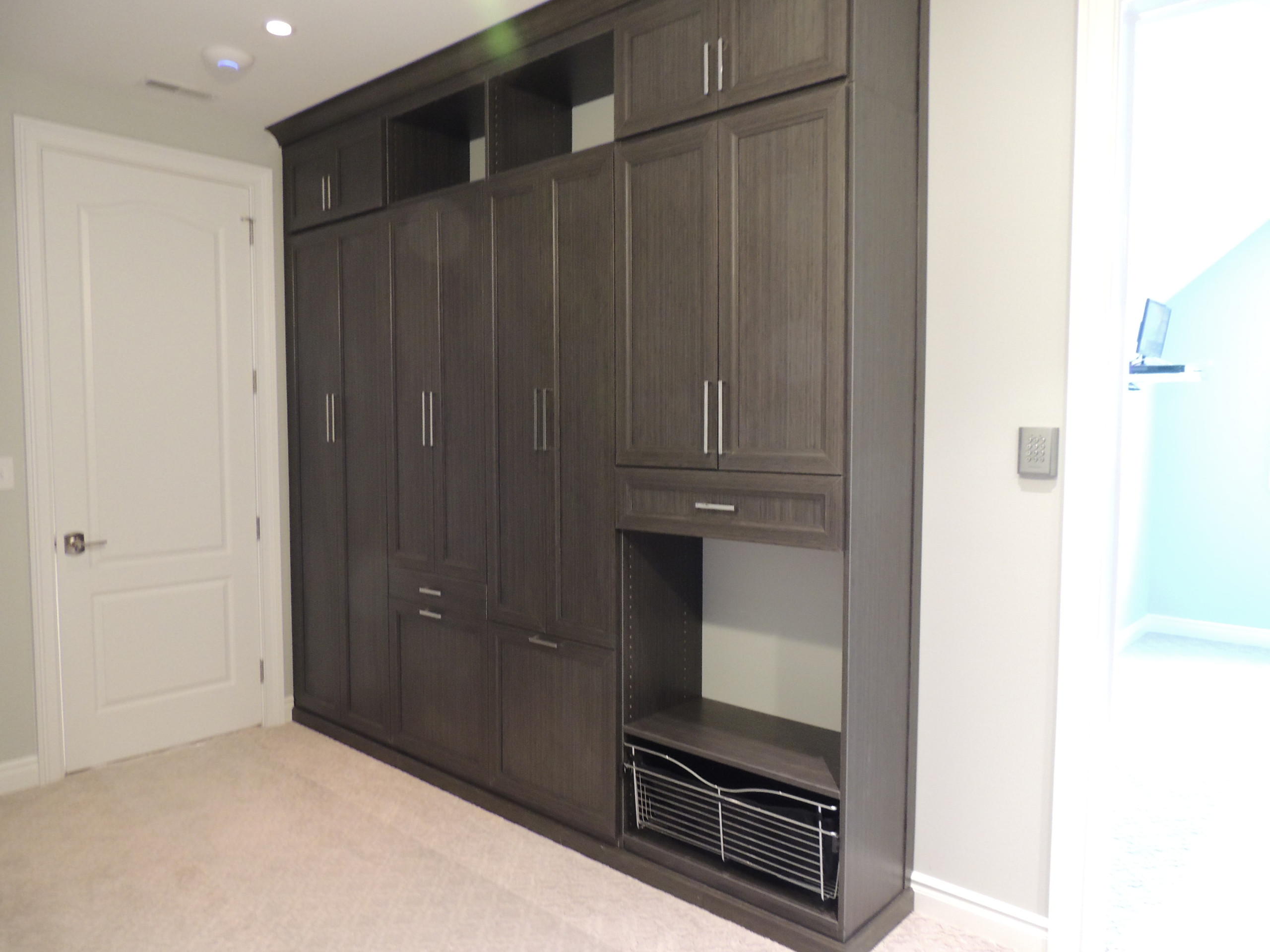 Shaker door cabinets for hamper and ironing board storage.