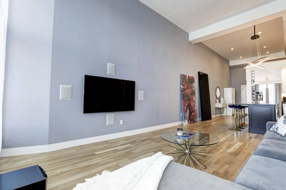 Inspiration for a large modern loft-style living room in New York with a music area, grey walls, light hardwood floors and a built-in media wall.