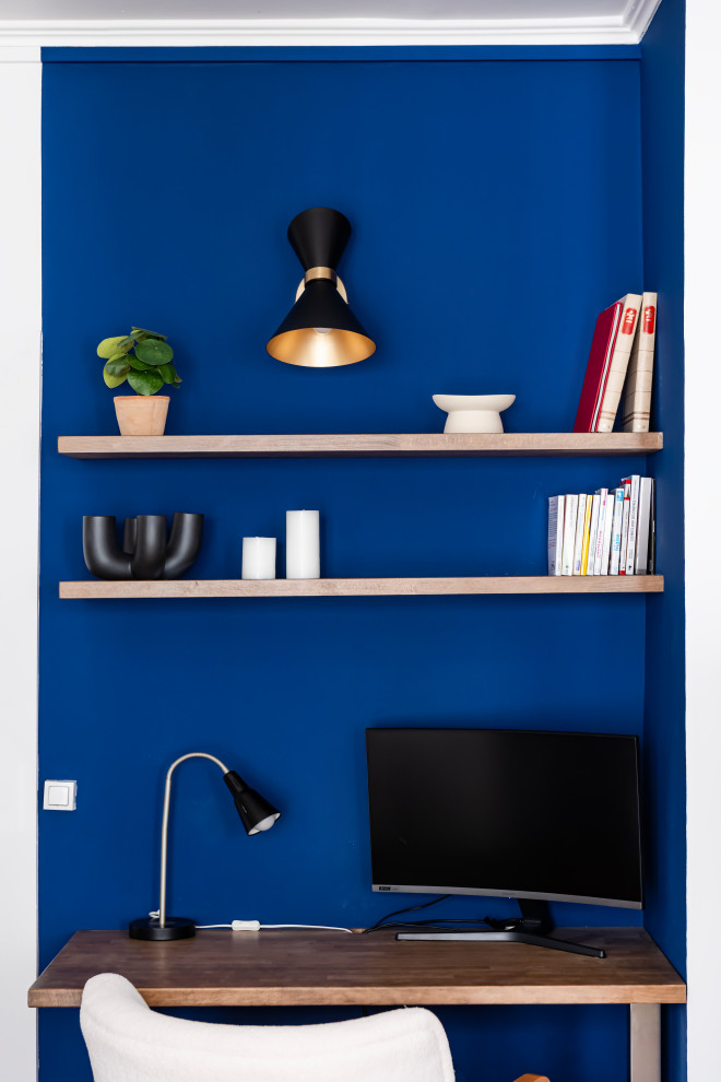 Mittelgroßes Modernes Arbeitszimmer ohne Kamin mit blauer Wandfarbe, braunem Holzboden und beigem Boden in Paris