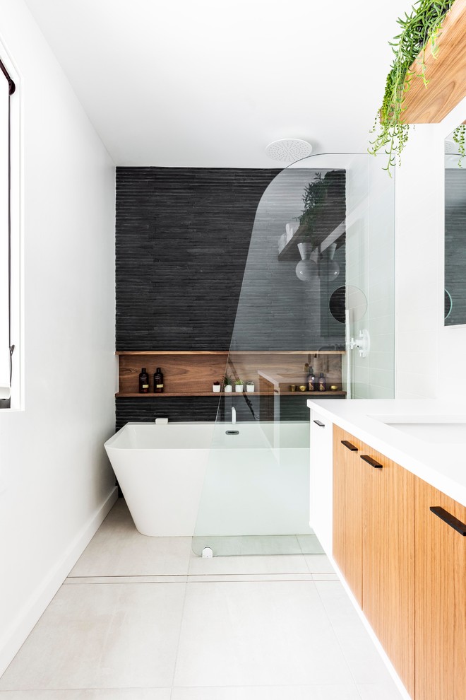 Inspiration for a mid-sized modern master bathroom in Portland with flat-panel cabinets, medium wood cabinets, a corner shower, a wall-mount toilet, white tile, subway tile, brown walls, porcelain floors, an undermount sink, quartzite benchtops, grey floor, a hinged shower door and white benchtops.