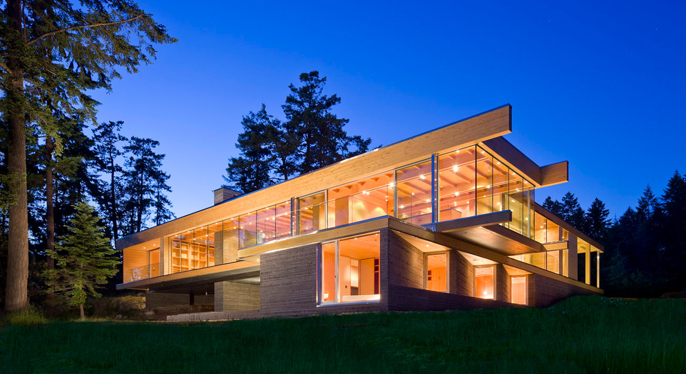 Inspiration for a modern two-storey glass brown house exterior in Vancouver with a flat roof.