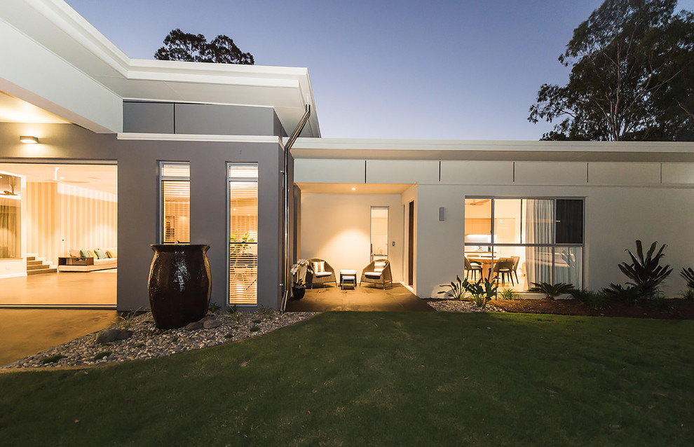 Expansive contemporary one-storey concrete beige exterior in Brisbane with a flat roof.